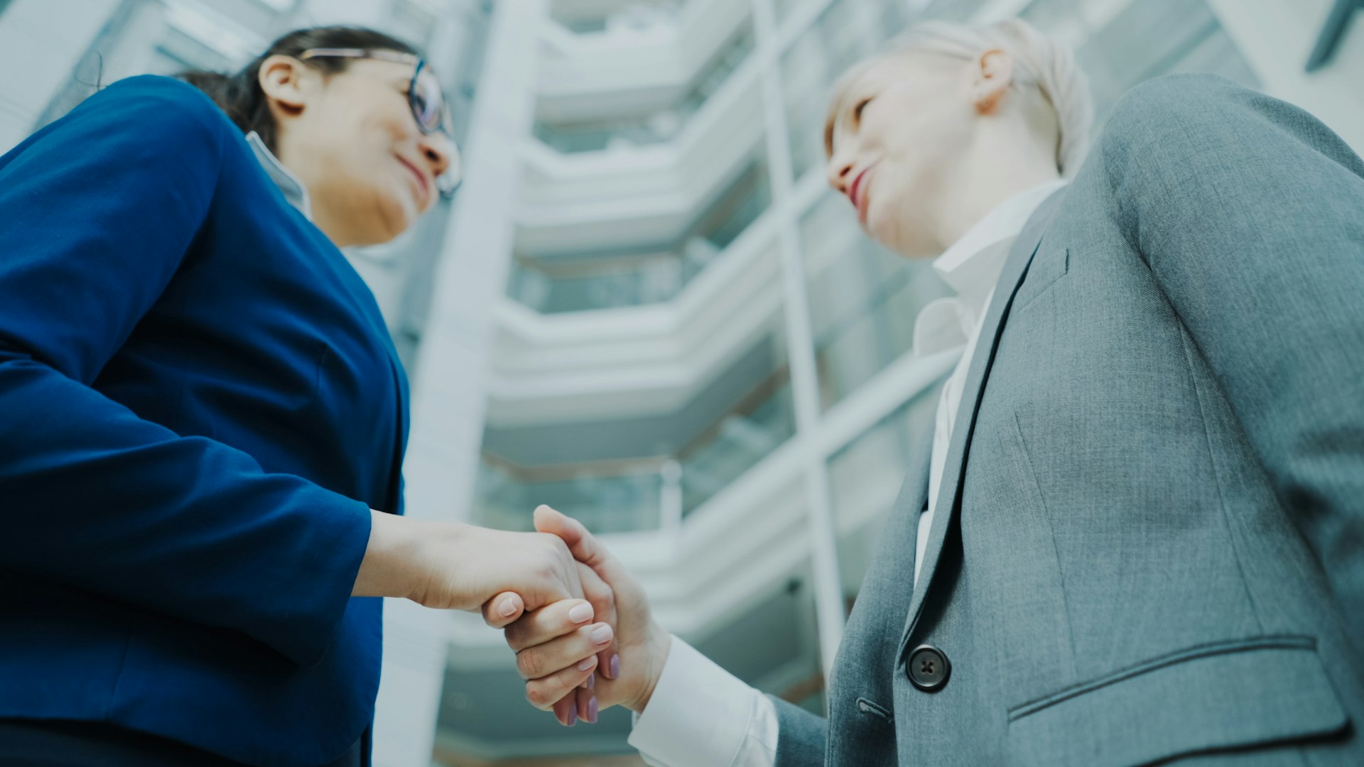 Due imprenditrici si stringono la mano nell atrio di un ufficio