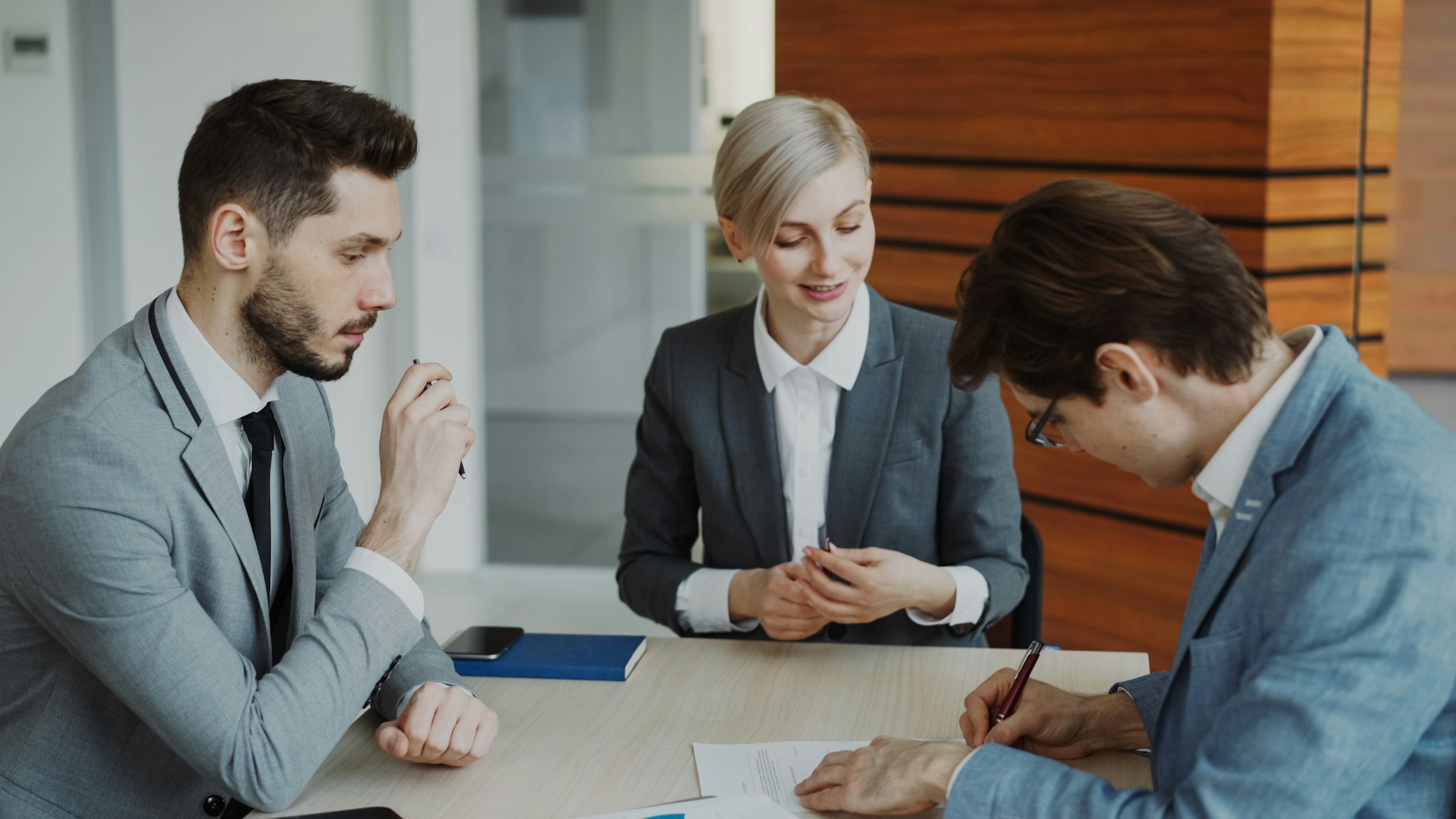 Consulente che illustra un contratto a un imprenditore durante un incontro in ufficio